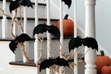 05 a branch covered with black paper bats with red eyes and pumpkins on the steps to style the space for Halloween easily