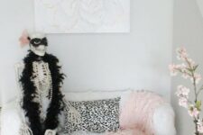 06 a glam nook with a skeleton dressed in jewelry and a fur scarf, with black and pink pumpkins is a romantic and cute idea