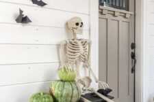 09 a rustic Halloween porch with heirloom pumpkins, a skeleton and some bats on the wall is a cool idea