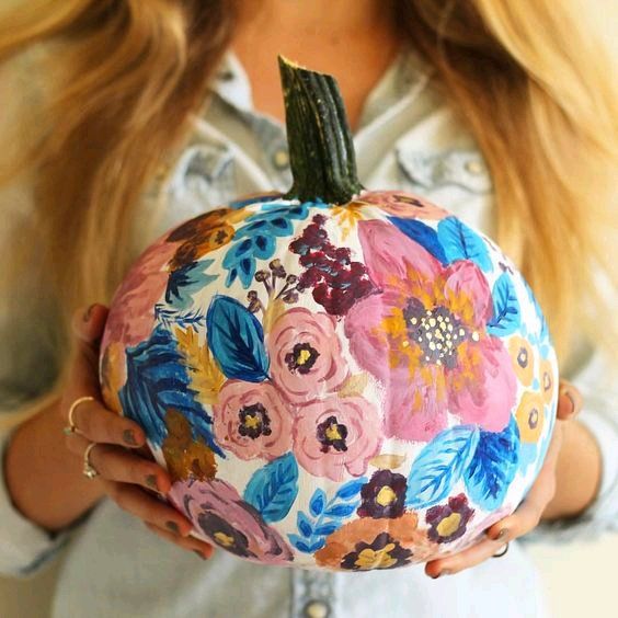 a white pumpkin painted with blue leaves and pink blooms is a beautiful and cute solution for a pastel fall space