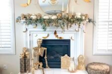 11 a white and gold Halloween fireplace with greenery, skulls, a skeleton, candles and bats