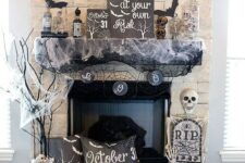 13 Halloween fireplace styling with bats, spider web, a skeleton, a pillow, branches and a bunting is a cool idea