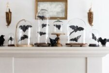 14 a Halloween mantel decorated with black paper bats in cloches and with blackbirds is a cool idea to go for