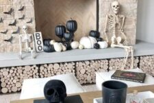 14 modern Halloween styling with a couple of skeletons and skulls, black and white pumpkins, paper bats and a sign