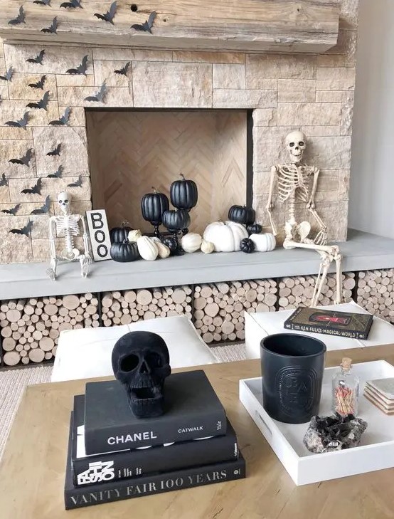 modern Halloween styling with a couple of skeletons and skulls, black and white pumpkins, paper bats and a sign