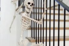 15 skeletons climbing up the railing are a fun and very easy idea to style your home for Halloween and you can realize that very quickly