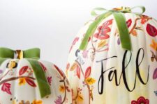 15 white pumpkins decorated with pink, red and burgundy painted blooms and leaves and topped with green bows for the fall