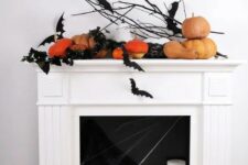 17 a modern Halloween fireplace with black bats, pumpkins, pillar candles and a bucket with a pumpkin