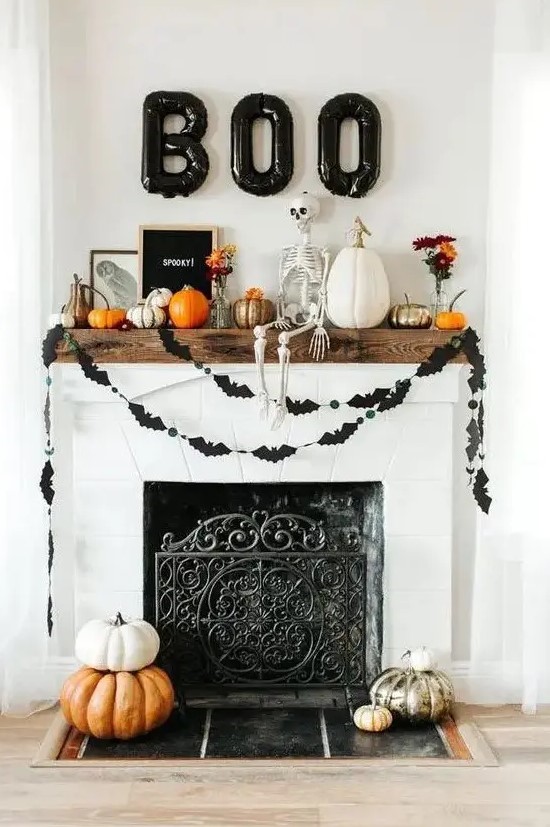 a modern Halloween mantel with a skeleton, balloon letters, buntings, pumpkins and signs