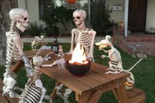 19 a cool outdoor bbq scene done with skeletons and skeleton dogs plus jack-o-lanterns is a very fresh and fun idea