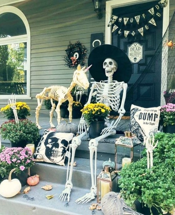 a funny Halloween porch scene with a skeleton and a skeleton unicorn, pumpkins, candle lanterns, buntings and black spider web