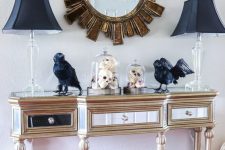 28 a refined entryway console with black lamps, blackbirds, black candleholders, a black house and Halloween trees