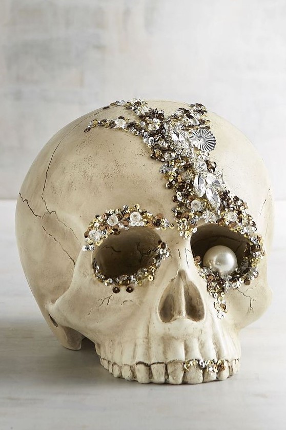 A refined glam Halloween decoration   an embellished skull with rhinestones, sequins and a large pearl as an eye is amazing