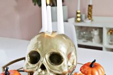 30 a simple Halloween arrangement of a tray with candy corns, faux pumpkins, spiders and a gold skull as a candleholders