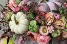 33 a lilac pumpkin decorated with pink, mauve and neutral blooms, berries, greenery and dark foliage and small pumpkins