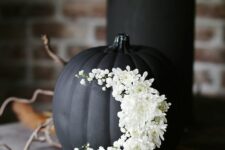 34 a matte black pumpkin decorated with white blooms is a very sophisticated and chic idea for Halloween