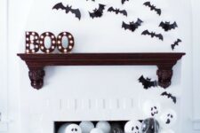 34 paper bats over the mantel, marquee letters and black and white balloons in the fireplace for Halloween styling