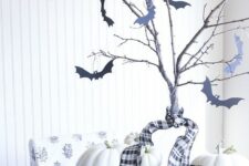 36 simple farmhouse Halloween decor with a basket with white pumpkins, branches with black bats attached to them