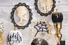 40 glam Halloween decor with skull portraits, a black and gold dip pumpkin, a bejeweled skull and candles