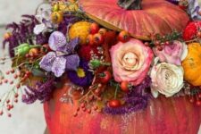 43 a super colorful fall pumpkin decirated with white, purple and pink blooms, berries and fruits and greenery is amazing
