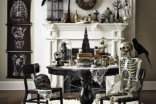 44 a vintage Halloween space with black posters, skeletons and skulls, blackbirds and wreaths, black furniture and a candle chandelier is wow