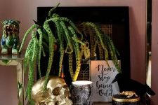 45 refined and glam Halloween styling with an artwork, a crow, gold skulls and some candles