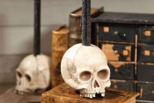 47 stacked vintage books with skulls as candleholders look very chic, nice and bold and make the space feel like Halloween