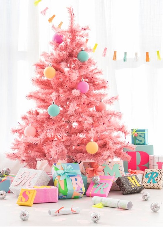 A cool candy pink Christmas tree decorated with a bit of pastel colored ornaments looks gorgeous, modern, fresh and very pretty