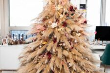 10 a pampas grass Christmas tree decorated with some metallic ornaments, bright blooms and lights is a bold boho decor idea