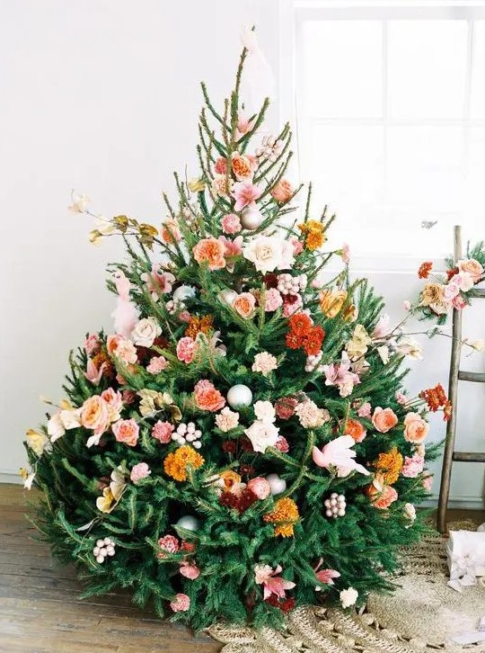 a beautiful Christmas tree with orange, rust, burgundy, blush and pink blooms, some branches and leaves is a very cute and romantic idea