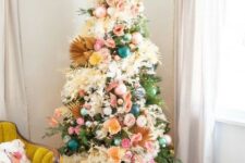 16 a boho Christmas tree with teal, green and pink ornaments, lights, fronds, pink, yellow blooms and pompoms is a chic idea