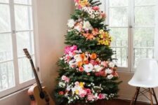 17 a Christmas tree decorated with blooms and lights is a unique boho chic idea to arise your inner flower child