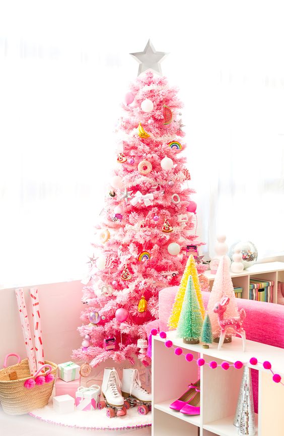 A pink Christmas tree decorated with various bold ornaments food themed and many others is a fun and cool idea