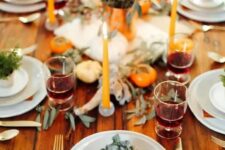 19 a bold rustic Thanksgiving table with rust napkins, pumpkins, greenery, a bold floral arrangement and bright candles