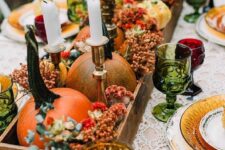 20 a bold Thanksgiving tablescape with orange pumpkins and berries, green, amber and burgundy glasses and tall and thin candles