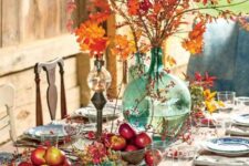 22 a bright and natural Thanksgiving tablescape with bold apple arrangements, berries, leaves and a bright fall leaf arrangement in a large vase