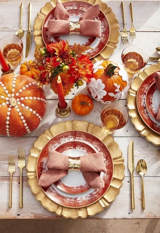 a bright and whimsy Thanksgiving tablescape with gold chargers, cutlery, colorful pumpkins and floral arrangements, bold candles