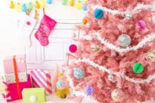 23 a pastel pink Christmas tree with colorful paper and glass Christmas ornaments and white garlands is a colorful modern solution