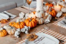 26 a bright rustic Thanksgiving tablescape with white and orange pumpkins, pillar candles, plaid placemats and leaves