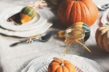 29 a natural tablescape with pumpkins, corn cobs, husks, candles and some elegant vintage plates