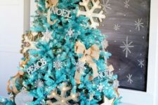30 a fabulous turquoise Christmas tree with lights, marquee snowflakes, letter decor, burlap bows and a basket to hide the base