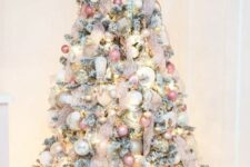 31 a flocked Christmas tree decorated with neutral, pink, silver ornaments, blush ribbon and a pink star topper