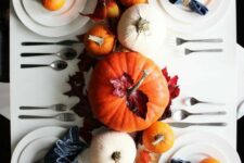 34 a simple and pretty modern Thanksgiving tablescape with white plates, white and orange pumpkins, fall leaves and indigo napkins