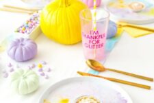 35 a pastel Thanksgiving tablescape with watercolor plates, pastel pumpkins and a runner, pastel candies and gold cutlery