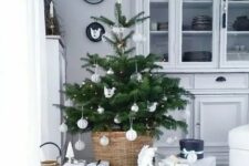 37 a small Nordic Christmas tree with lights and white and silver ornaments placed in a basjet and with neutral gift boxes under it is a chic idea for a modern space