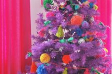 39 a purple Christmas tree decorated with colorful pompoms and tassels is a lovely idea for a bold holiday space