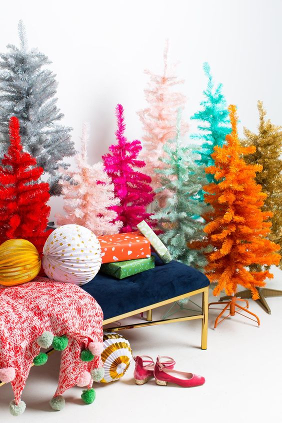 An arrangement of Christmas trees of various colors   mint, turquoise, pink, hot pink, orange, red and silver with no decor