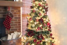 49 a Christmas tree with lights, gold ribbons, red, neutral and gold ornaments, poinsettia and stars