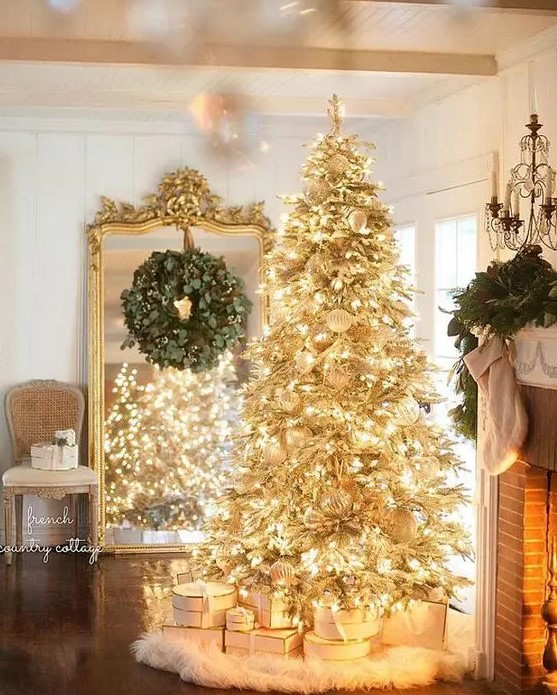 A gold pre lit Christmas tree with white ornaments and a faux fur skirt is a super glam and shiny idea for the holidays