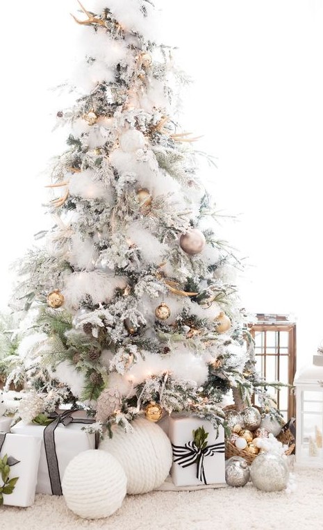 An enchanting Christmas tree with gold and copper ornaments, natlers, white faux fur garlands, antlers and pinecones is veyr glam like